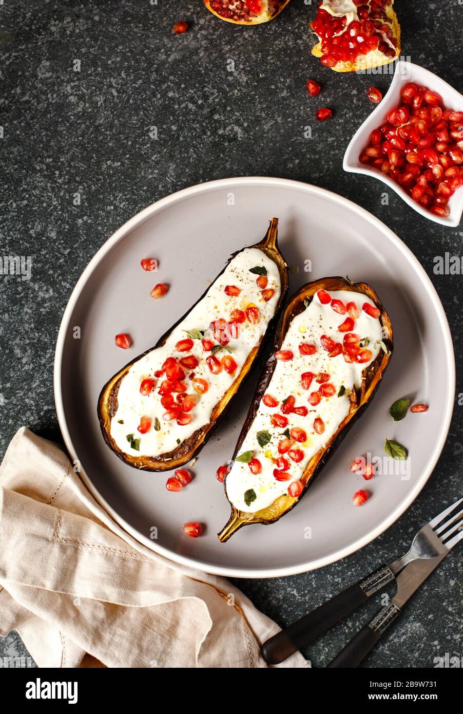 Baked eggplants with garlic yogurt sauce and pomegranate, top view