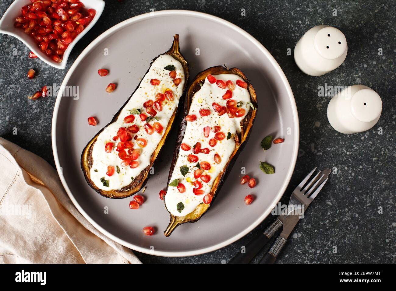 Baked eggplants with garlic yogurt sauce and pomegranate, top view