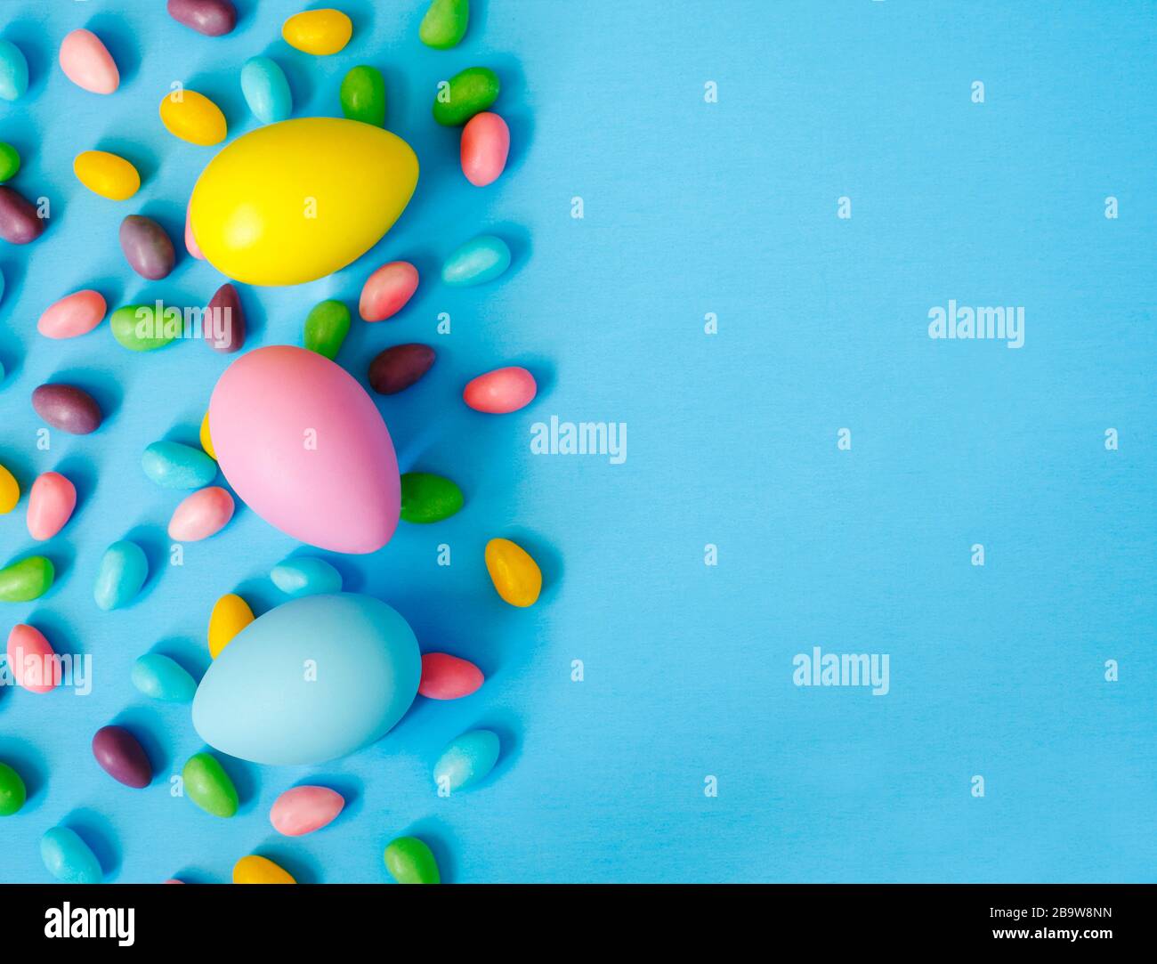 Easter decoration eggs and candy on blue background. Easter background, copy space Stock Photo