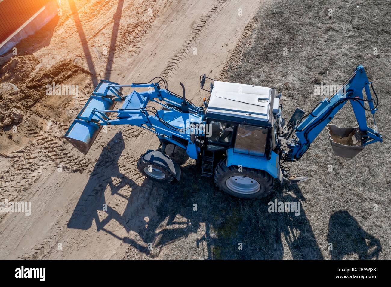 blue excavator buries a hole top view Stock Photo