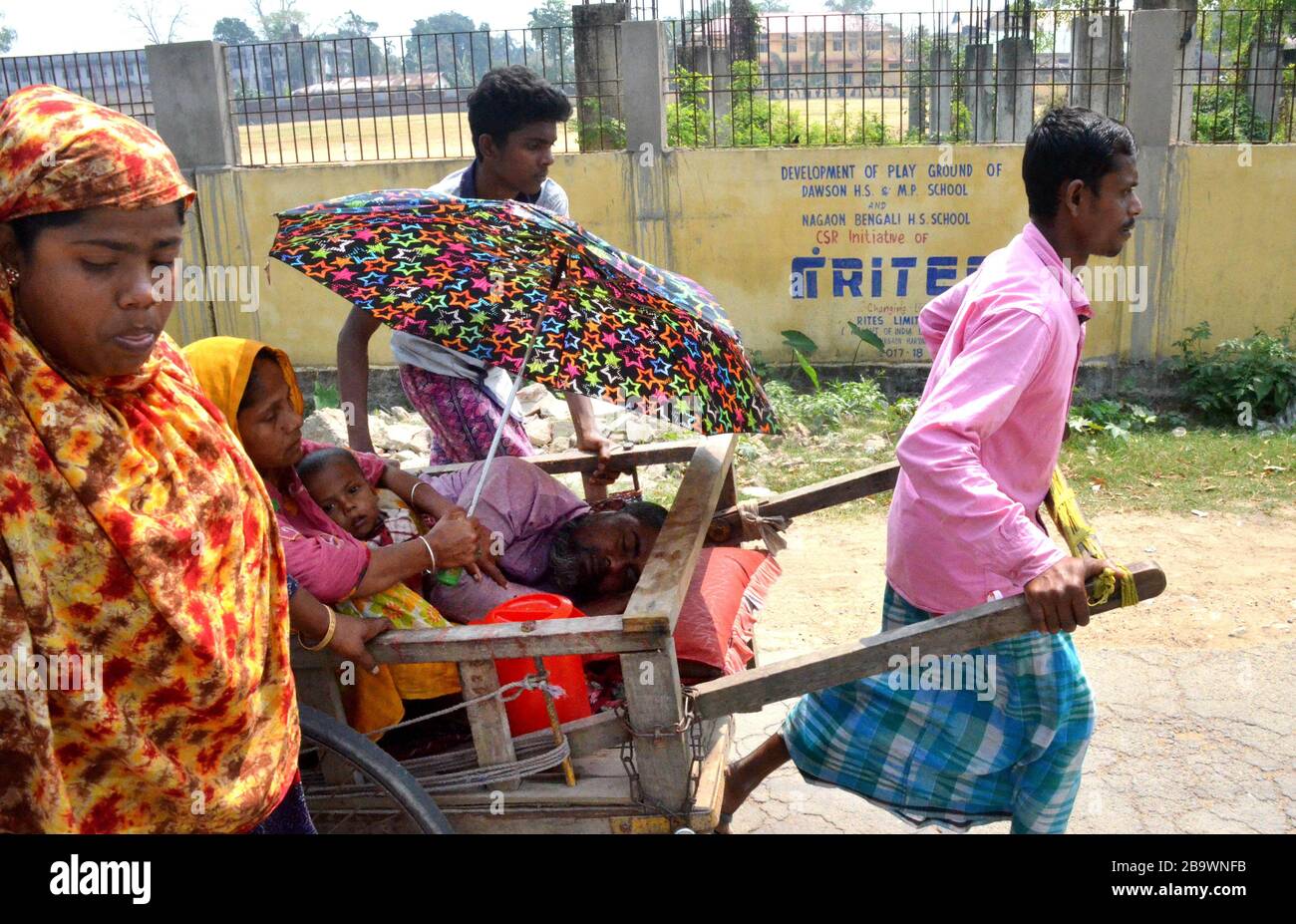 Nagaon / India - People carrying a patient in hand cart due to non availability of any vehicles during the Lock down called by the government of India. Stock Photo