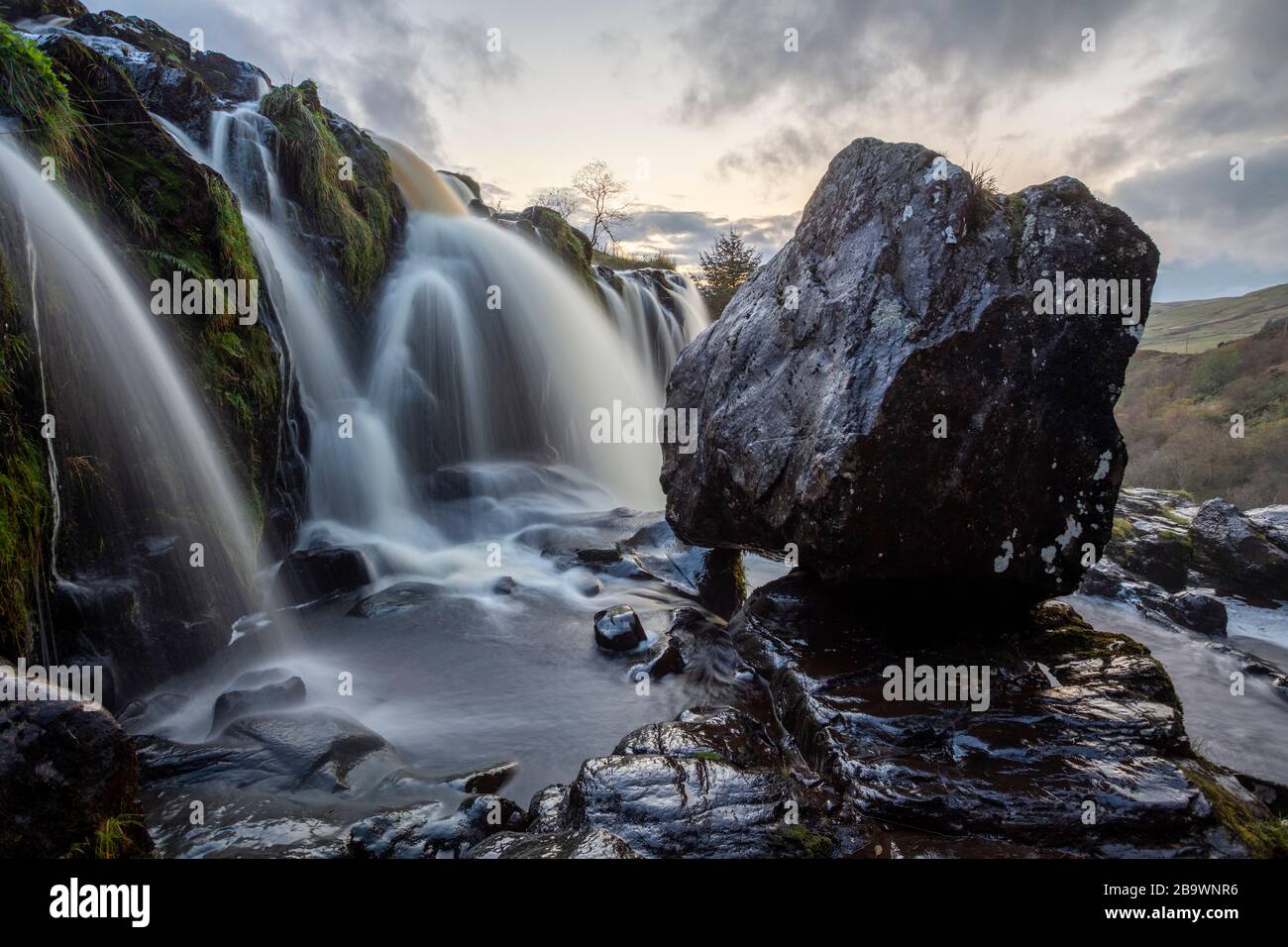 A huge boulder among the waterfalls of the Loup of Fintry, Stirling, Scotland. Stock Photo