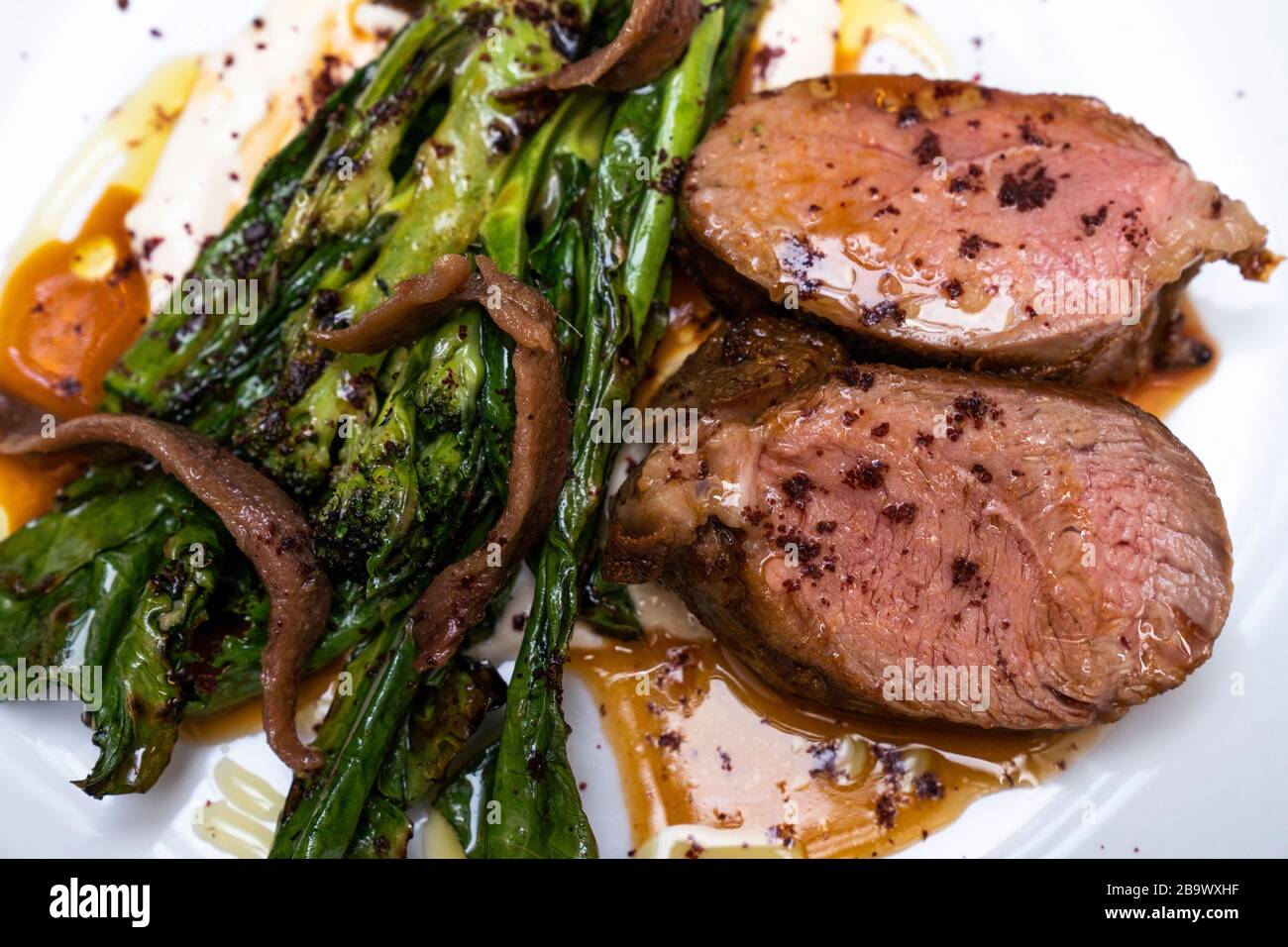 Lamb rump with purple sprouting broccoli, anchovy and roast garlic aioli Stock Photo