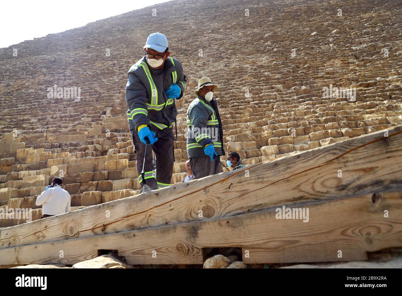 (200325) -- GIZA, March 25, 2020 (Xinhua) -- A staff member disinfects near the Pyramids in Giza, Egypt, March 25, 2020. Egypt announced on Tuesday that one COVID-19 case died and 36 new cases were detected, bringing the total number of cases in the country to 402. (Xinhua/Ahmed Gomaa) Stock Photo
