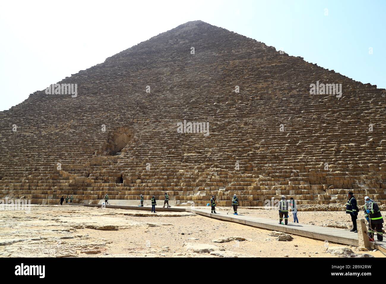 (200325) -- GIZA, March 25, 2020 (Xinhua) -- Staff members clean near the Pyramids in Giza, Egypt, March 25, 2020. Egypt announced on Tuesday that one COVID-19 case died and 36 new cases were detected, bringing the total number of cases in the country to 402. (Xinhua/Ahmed Gomaa) Stock Photo
