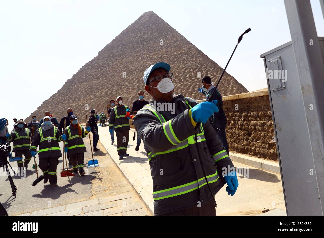 (200325) -- GIZA, March 25, 2020 (Xinhua) -- A staff member disinfects near the Pyramids in Giza, Egypt, March 25, 2020. Egypt announced on Tuesday that one COVID-19 case died and 36 new cases were detected, bringing the total number of cases in the country to 402. (Xinhua/Ahmed Gomaa) Stock Photo