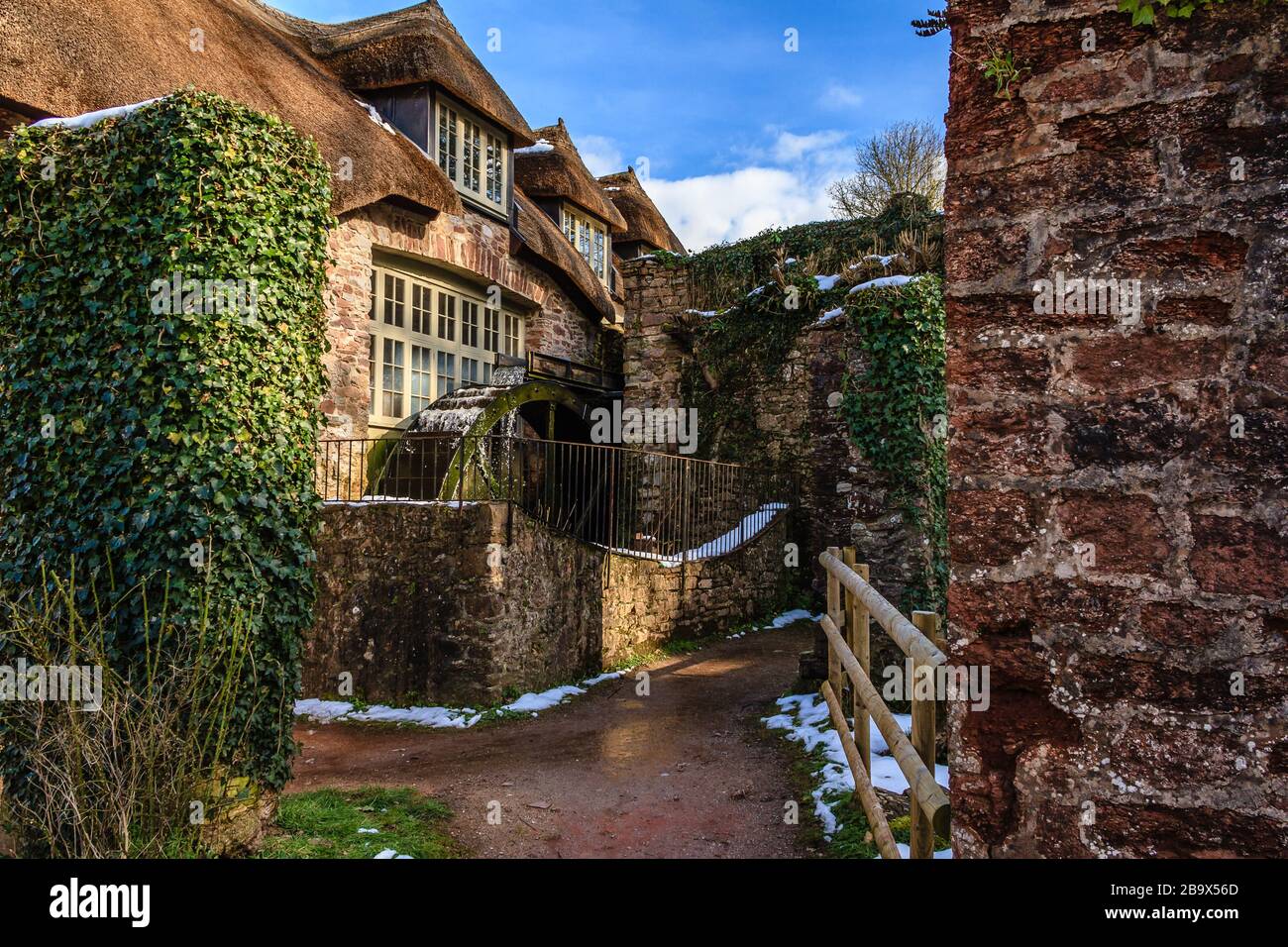 Cockington Mill Cottage with water wheel, in Cockington country park, Torquay, Devon, UK. March 2018. Stock Photo