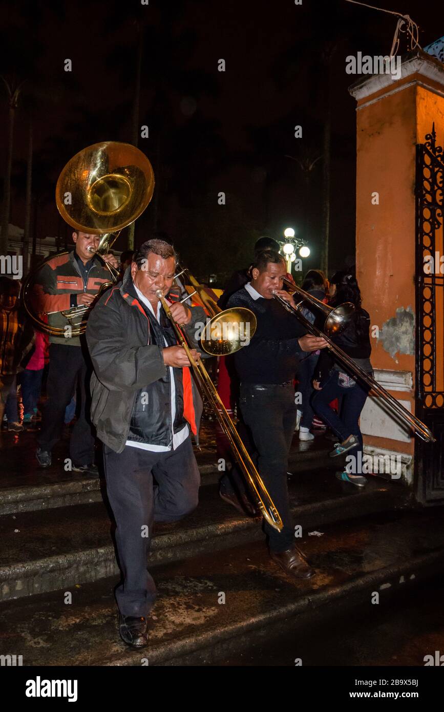 Brass musicians at procession, Festival of Our Lady of Guadalupe in December, rainy night in Coscomatepec, Veracruz state, Mexico Stock Photo