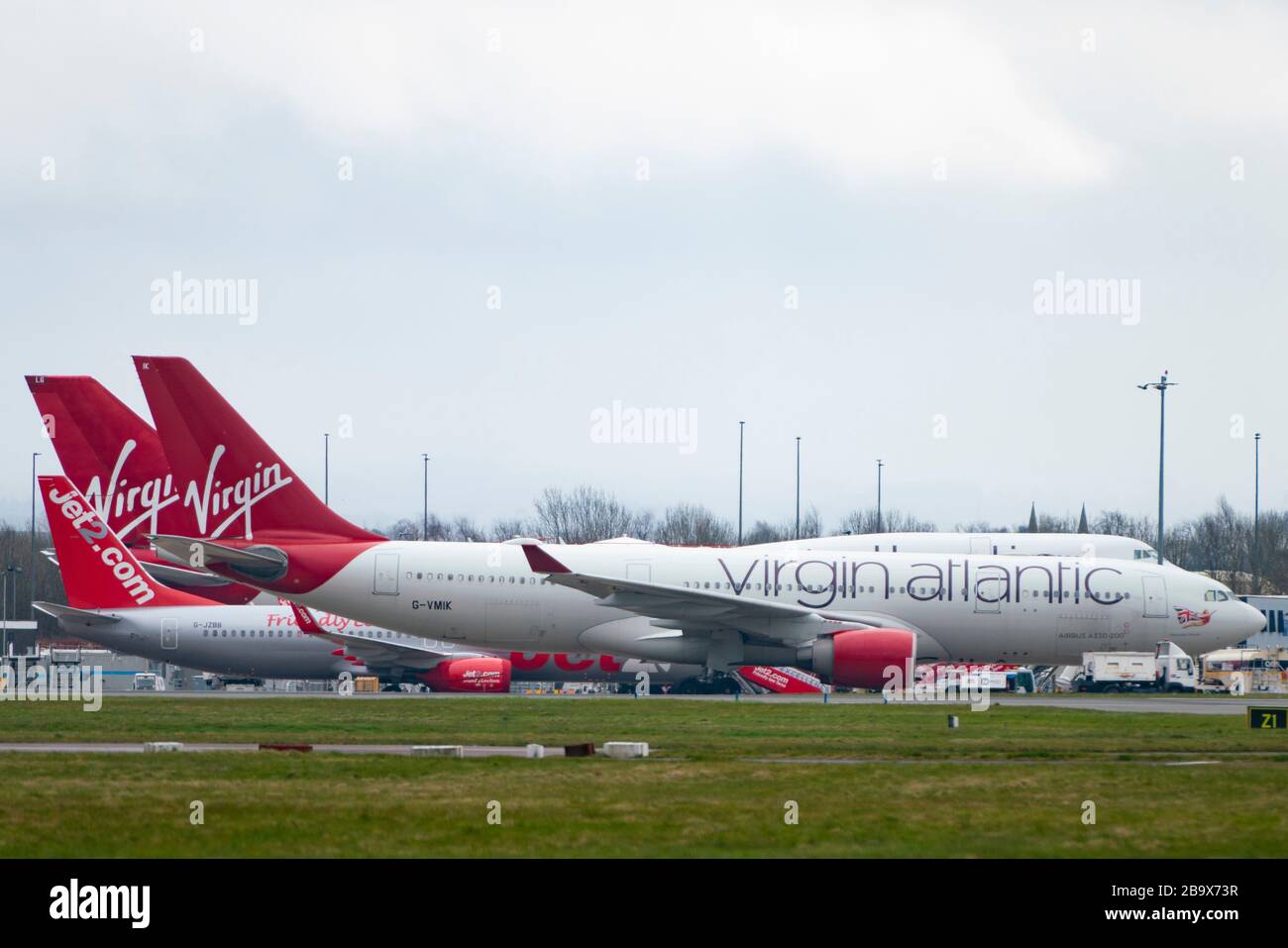 Glasgow, Scotland, UK. 25 March, 2020. Day two of the Government enforced lockdown in the UK. All shops and restaurants and most workplaces remain closed. Cities are very quiet with vast majority of population staying indoors. Pictured; Virgin Atlantic passenger aircraft remain grounded and parked at Glasgow Airport. Iain Masterton/Alamy Live News Stock Photo