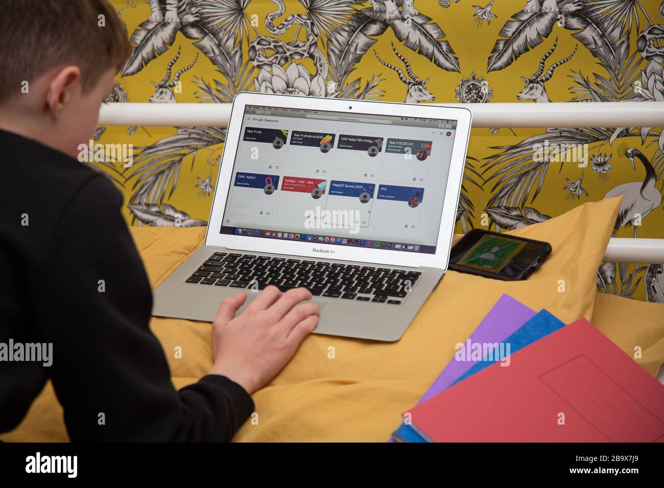 Boy works on his school work at home as schools are shut. Stock Photo