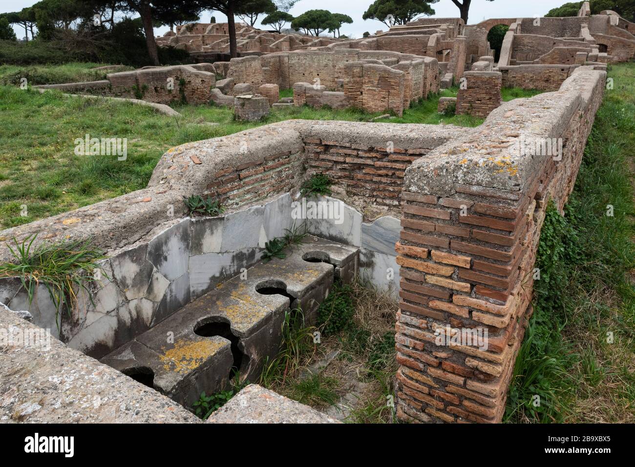 Rome. Italy. Ostia Antica. Remains of the Schola di Traiano (Schola Traianea / Guild-seat of Trajan).The latrine in the south corner of the building. Stock Photo