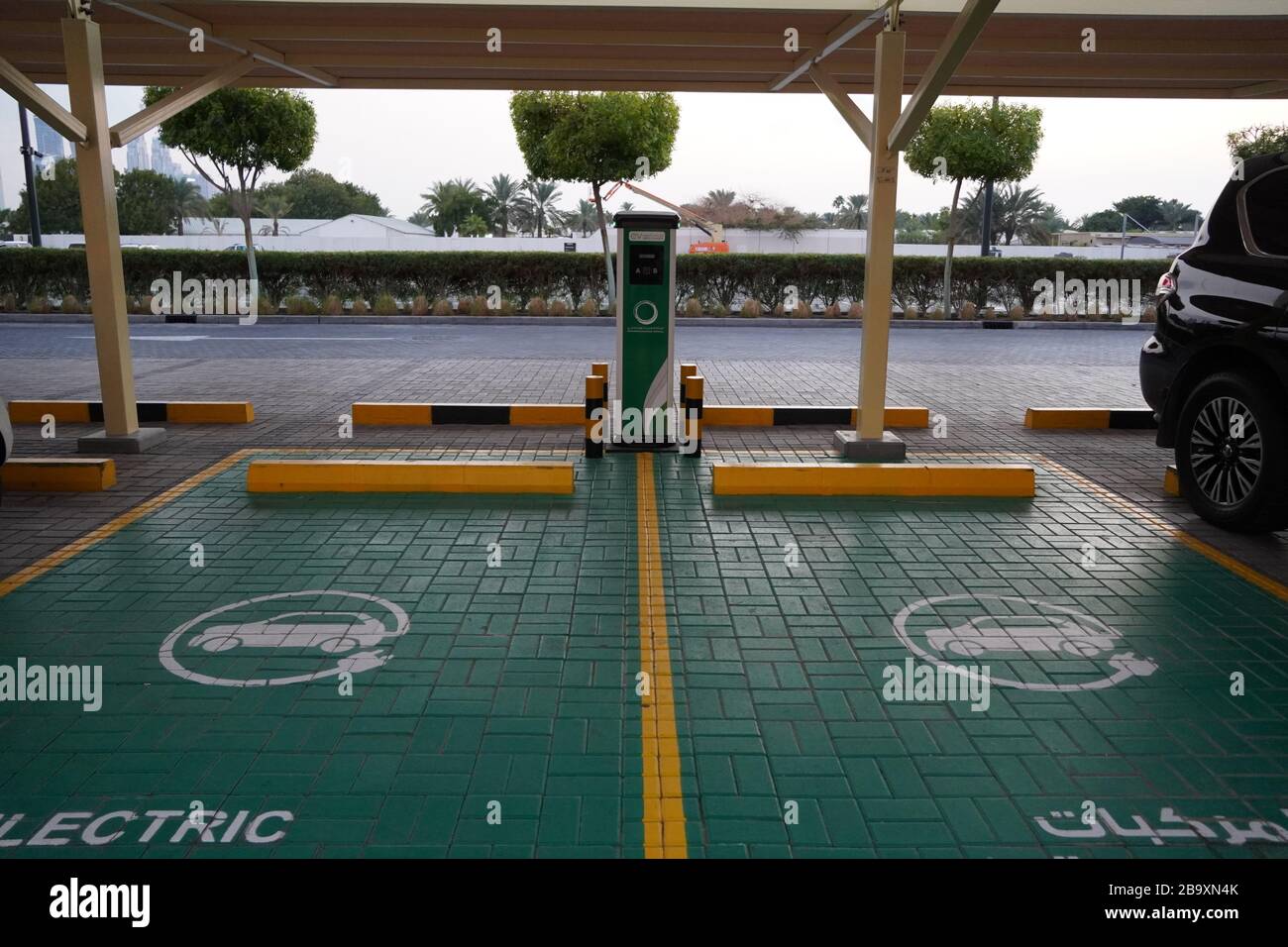 Green electric vehicle charging station sign in a parking bay. Electric