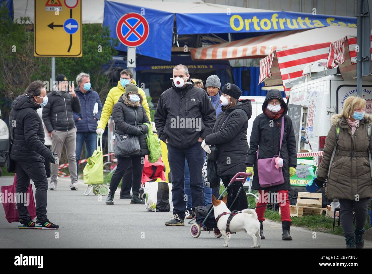 People standing line queue to shop, queue to outdoor marketplace. Social distancing. Preventive measures. Turin, Italy - March 2020 Stock Photo