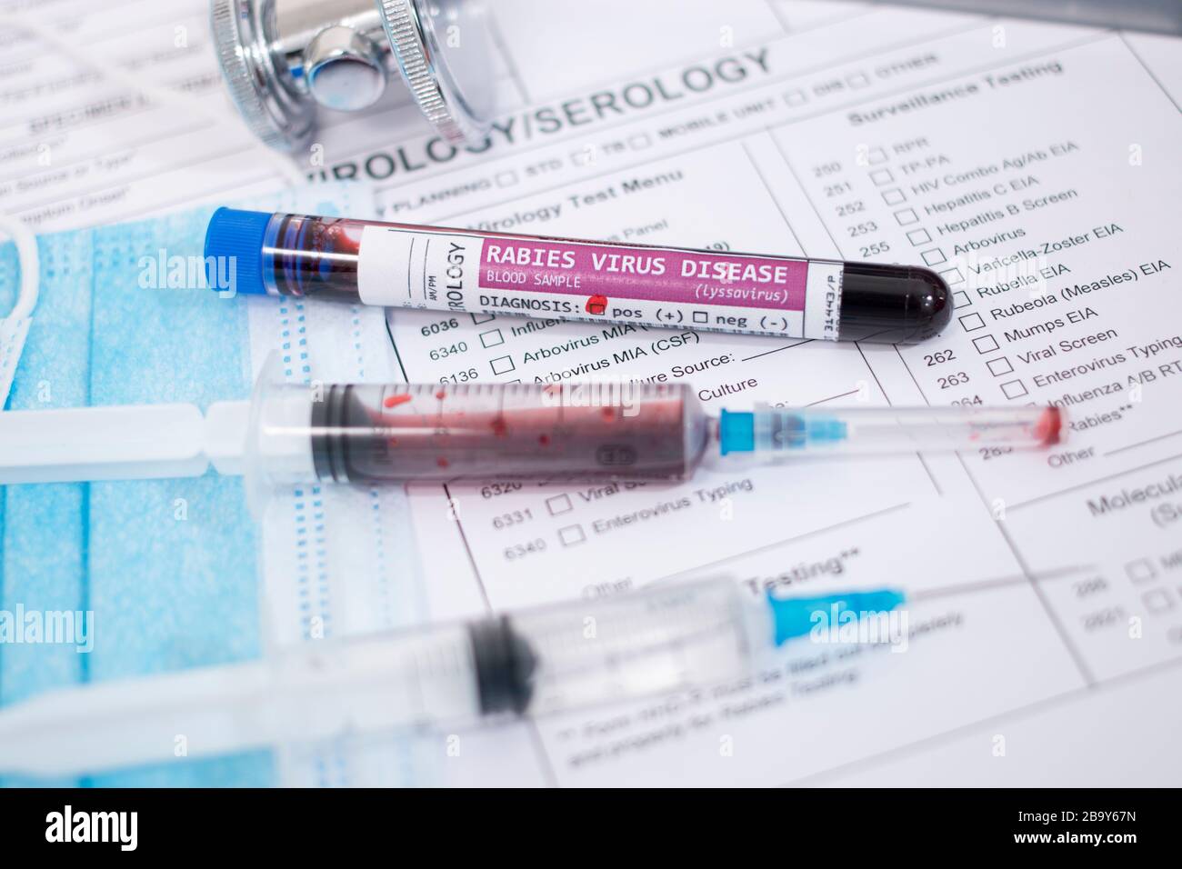 Fictional Blood samples with infected rabies virus, with mask, syringe and lab report. Stock Photo