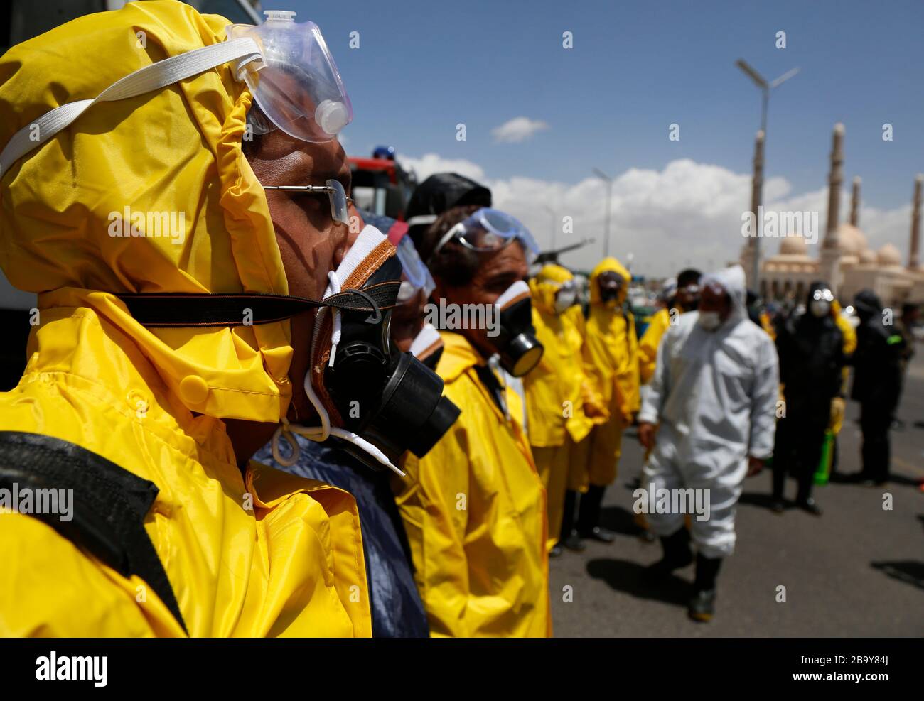 Sanaa, Yemen. 25th Mar, 2020. Workers gather before spraying