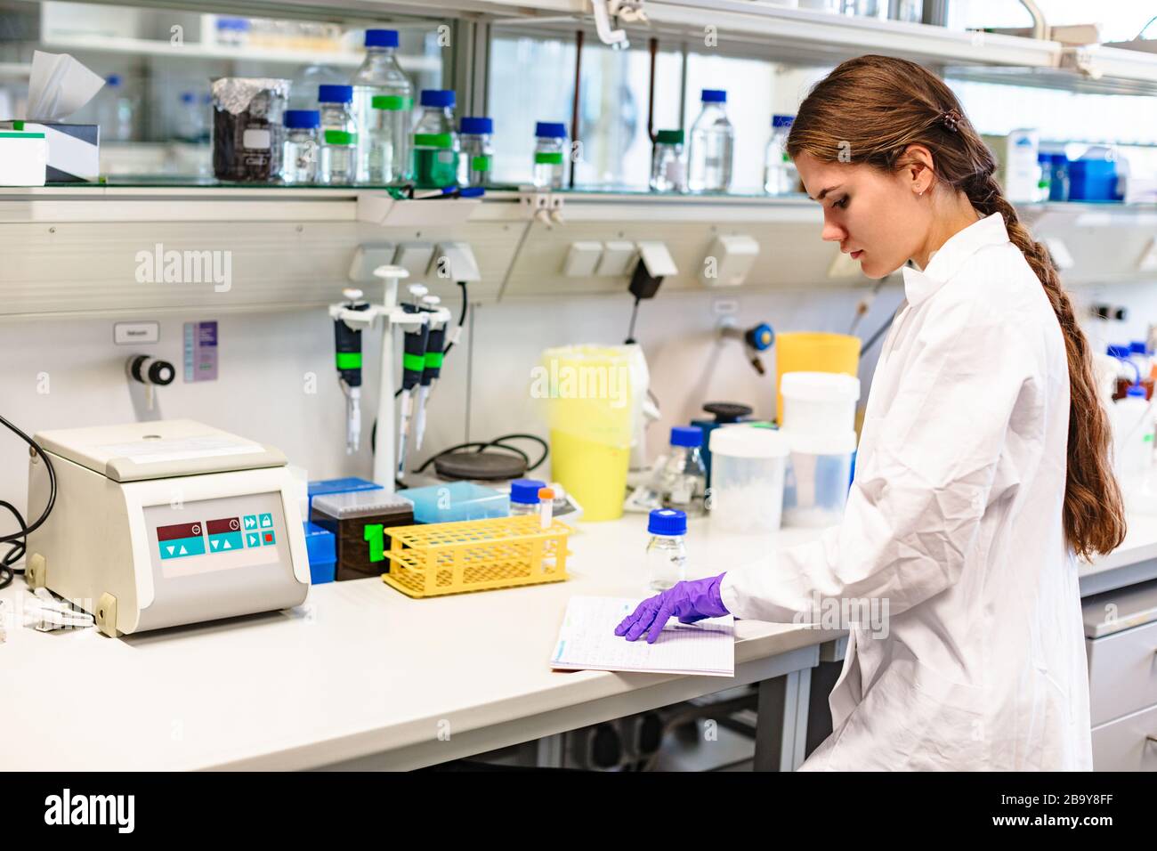 Girl scientist studying notes near lab equipment Stock Photo Alamy