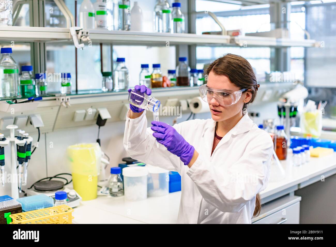 Girl in laboratory preparing solution or vaccine Stock Photo