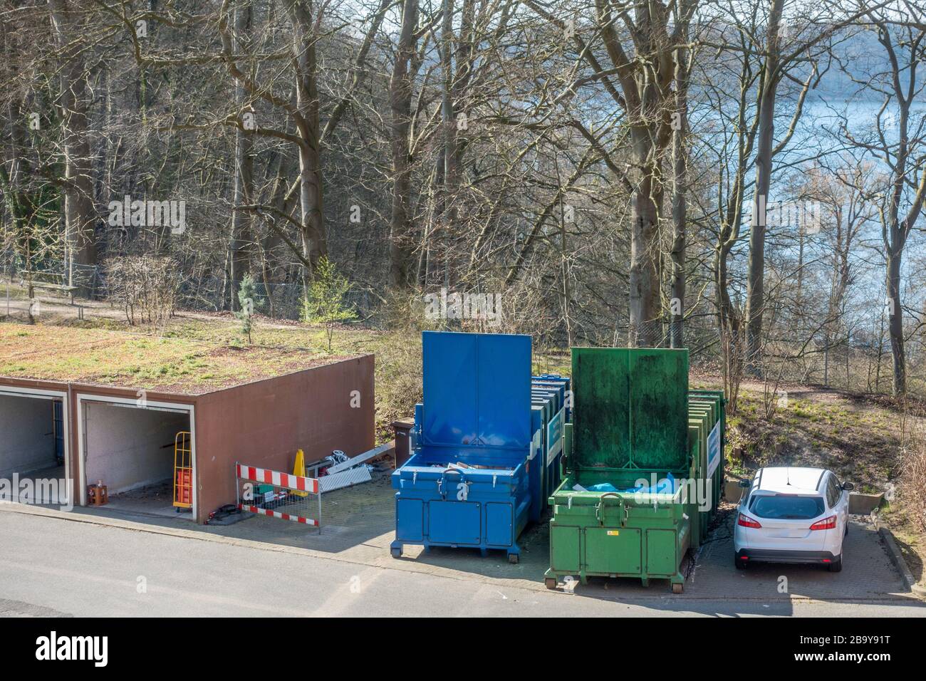 in the yard of a hospital, two waste compactors stand side by side ...
