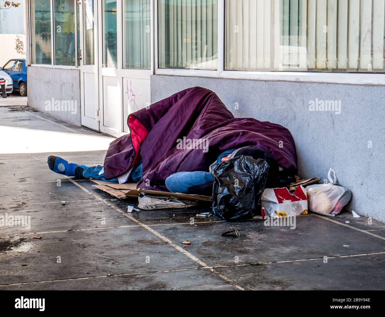 Homeless man sleeping on the street and covered with blanket. Homeless