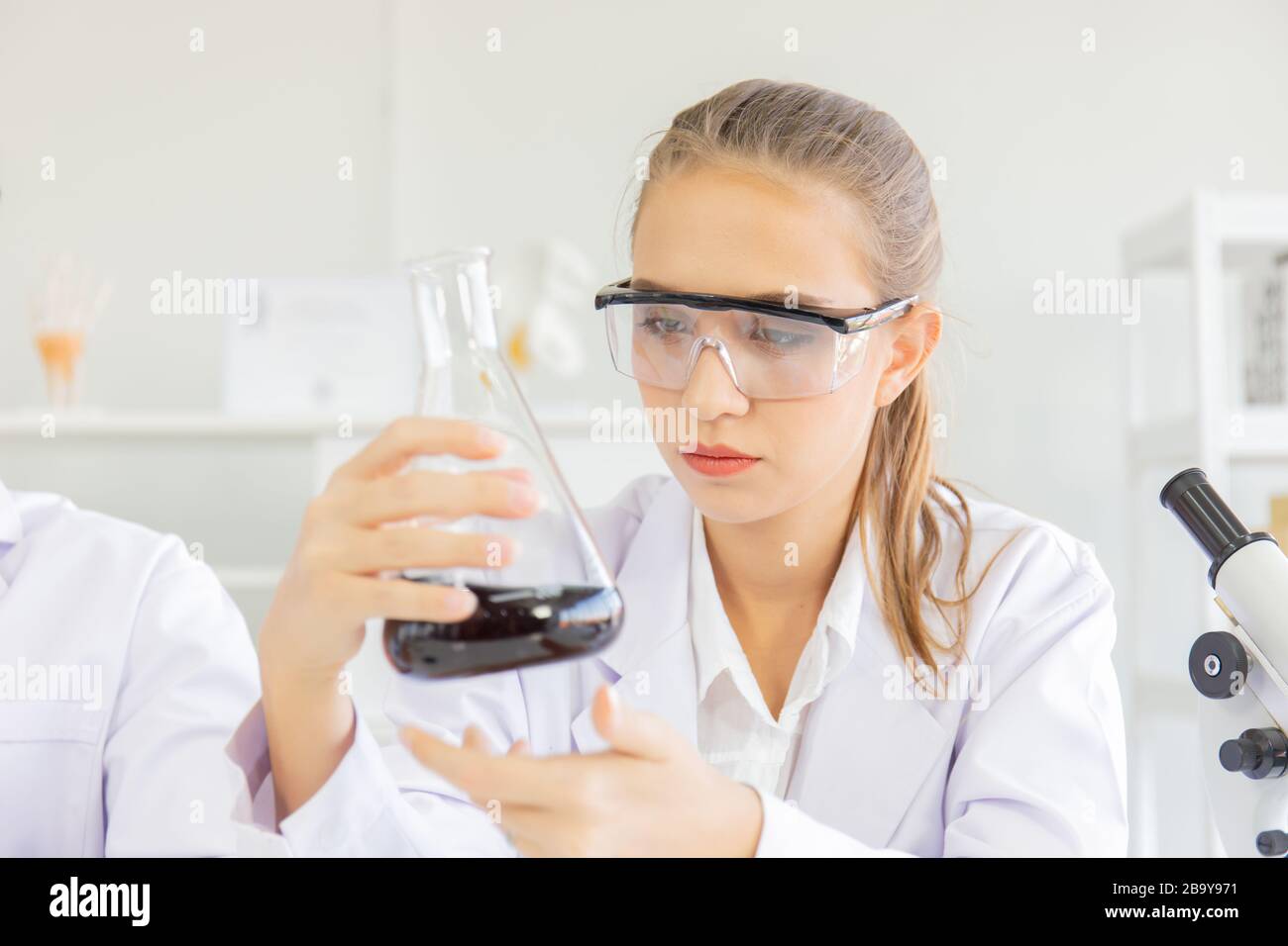 A beautiful female scientist is operating in a science lab with various equipment in the lab