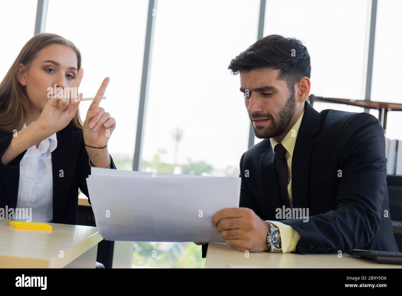 Two young business men, men and women, Dew, work at the office with seriousness. Stock Photo