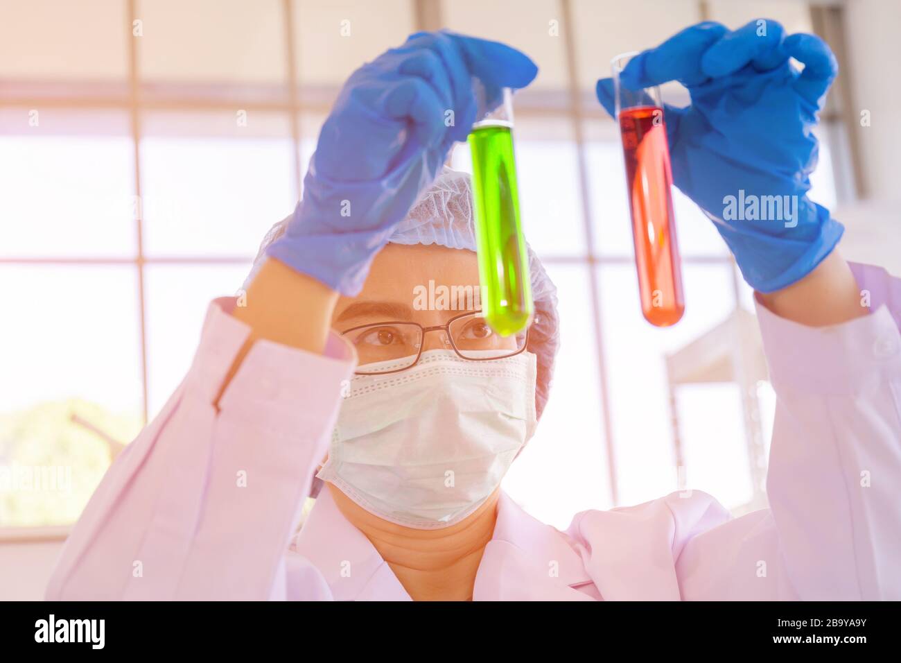 An Asian female scientist is researching a chemical formula in a lab. Stock Photo