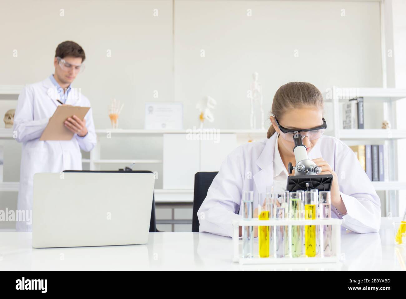 concept of a healthcare researcher, a researcher working in a life science lab, a young research scientist and a male supervisor preparing and analyzi Stock Photo