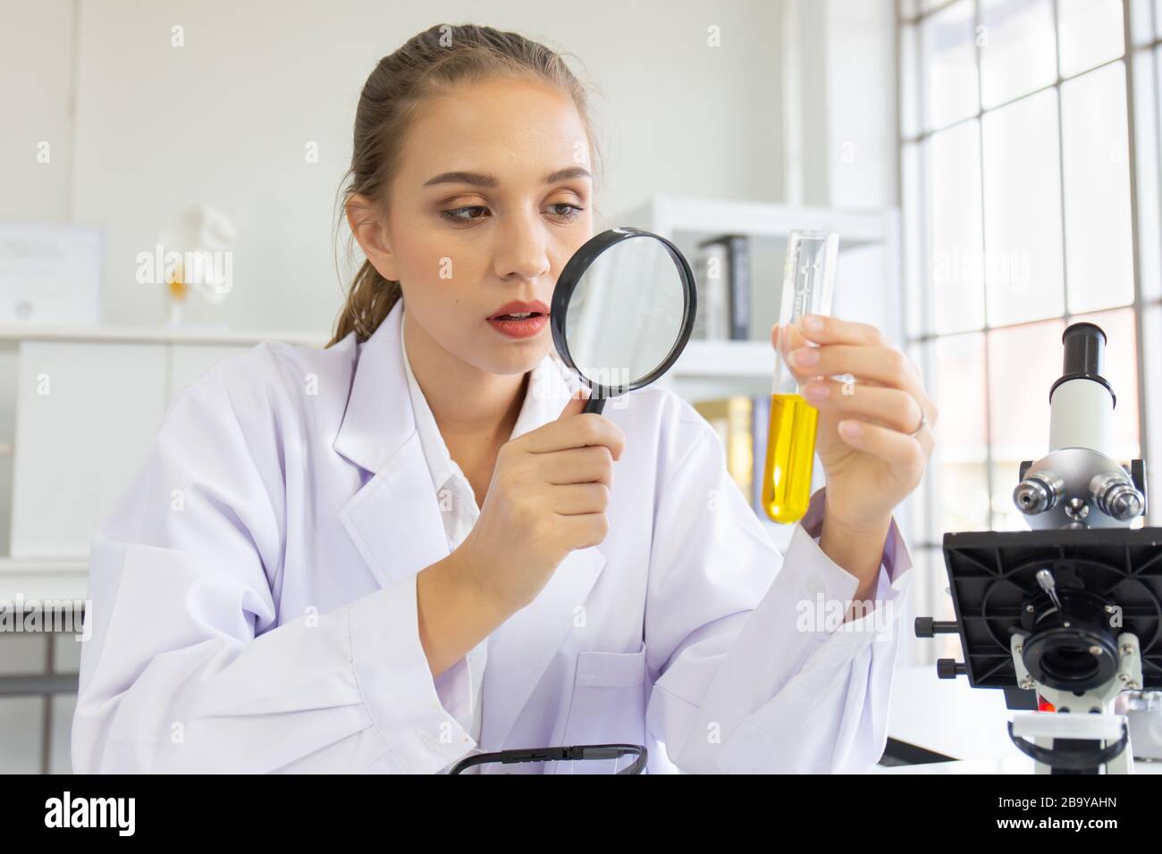 A beautiful female scientist is operating in a science lab with various