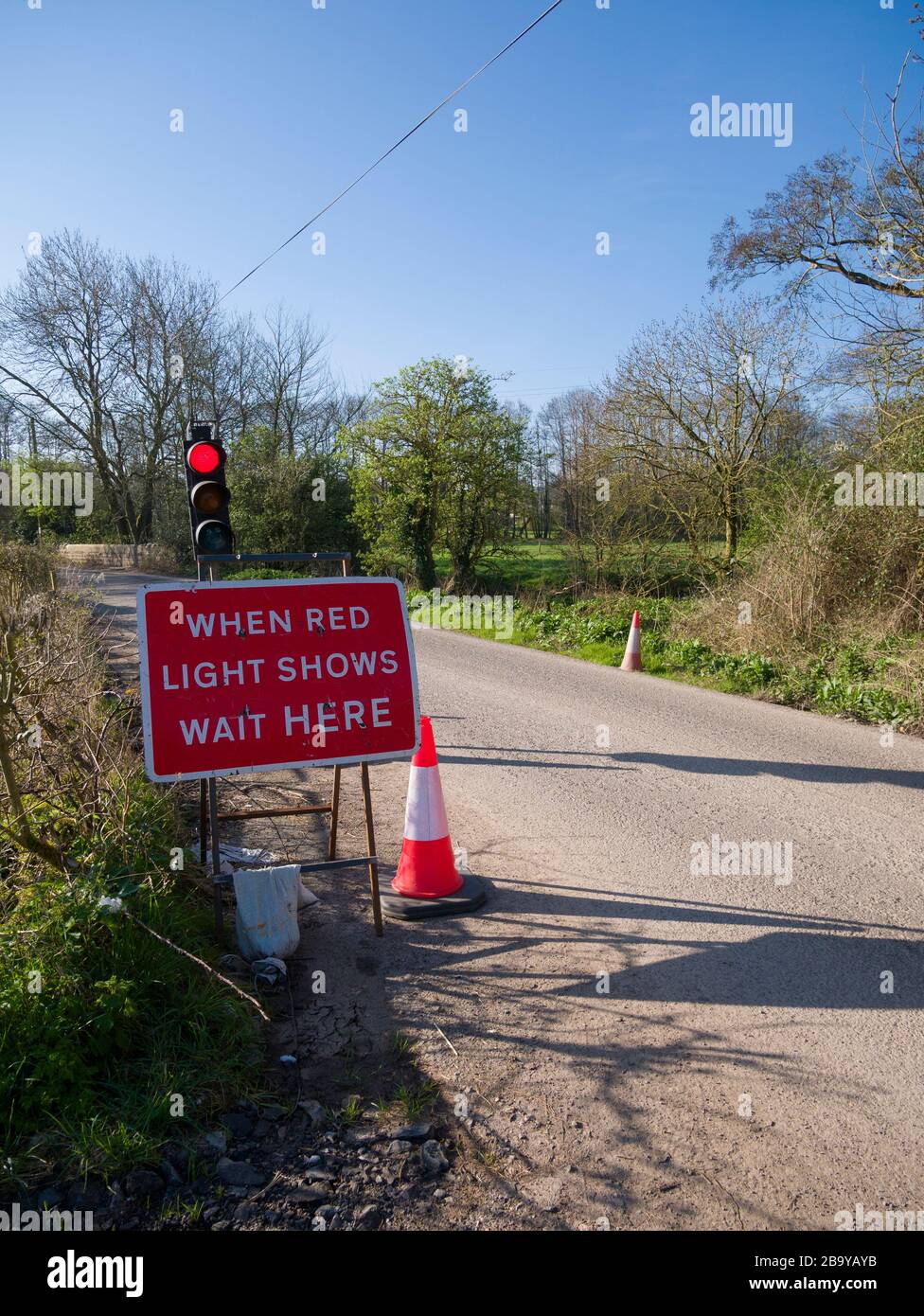 Temporary traffic lights in a country lane due to roadworks Stock Photo ...
