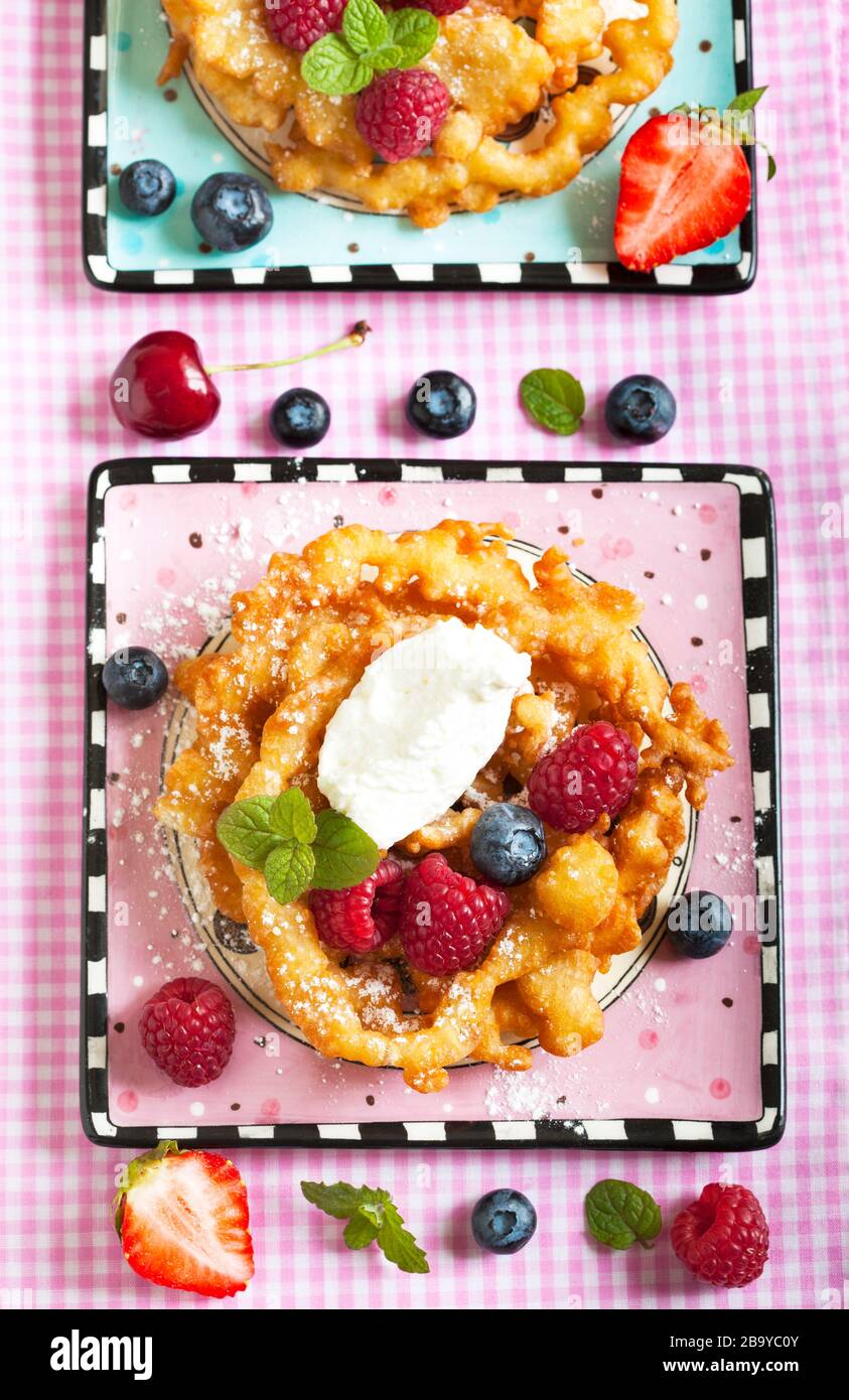 Funnel cakes with fresh berries and whipped cream Stock Photo Alamy