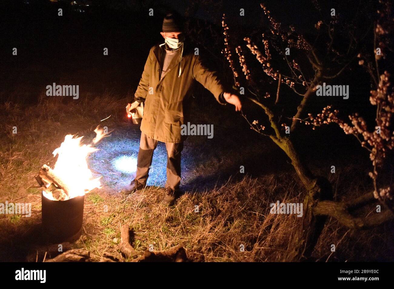 Velke Pavlovice, Czech Republic. 25th Mar, 2020. Owner of a company Jan Krejcirik ignites fire to protect fruit trees against frost in orchard of the 'Merunky Velke Pavlovice' company, on March 25, 2020, in Velke Pavlovice, Breclav, Czech Republic. Credit: Vaclav Salek/CTK Photo/Alamy Live News Stock Photo