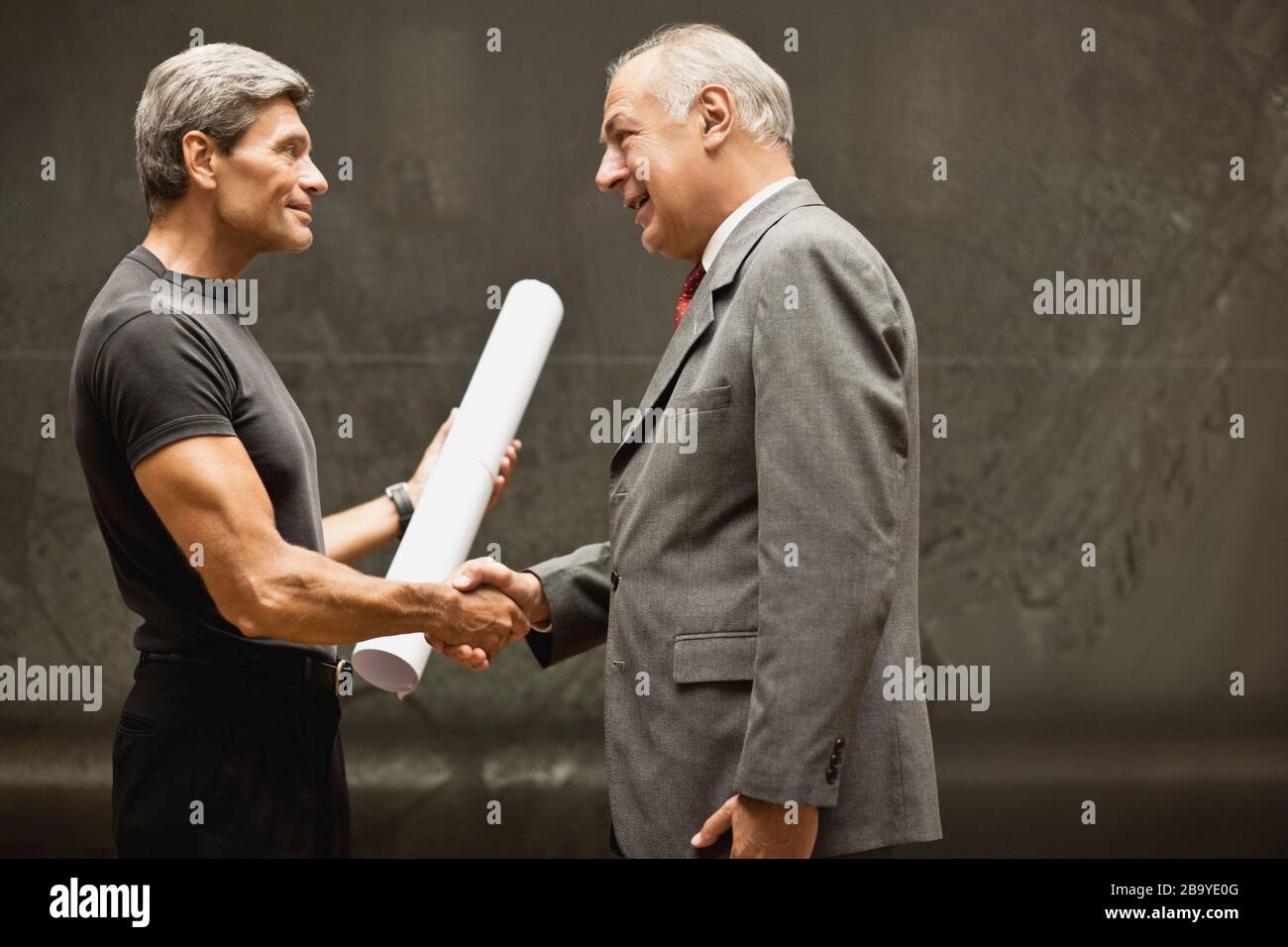 Architect handing blueprints to businessman. Stock Photo