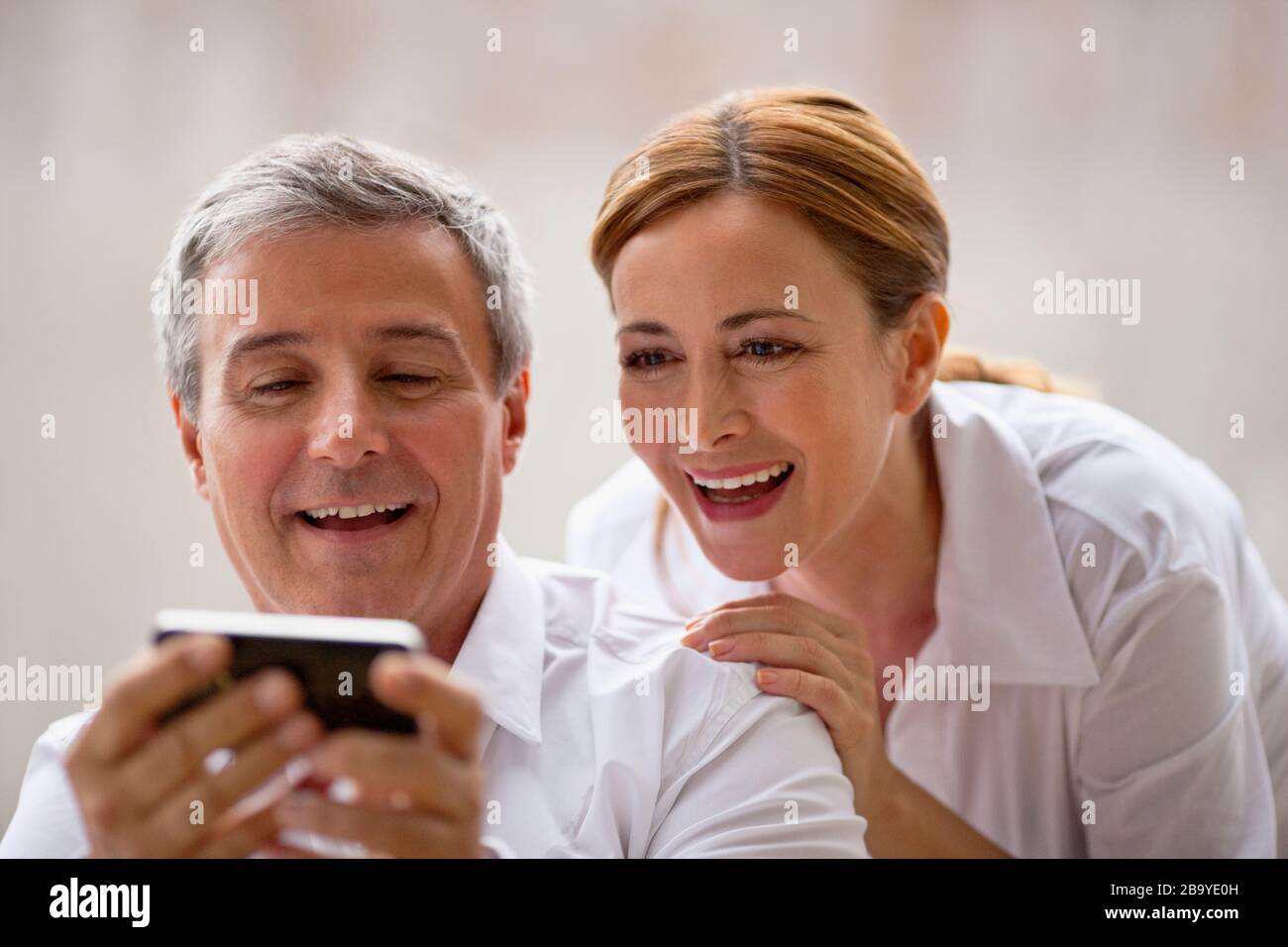 Professional couple looking at something on an iphone. Stock Photo