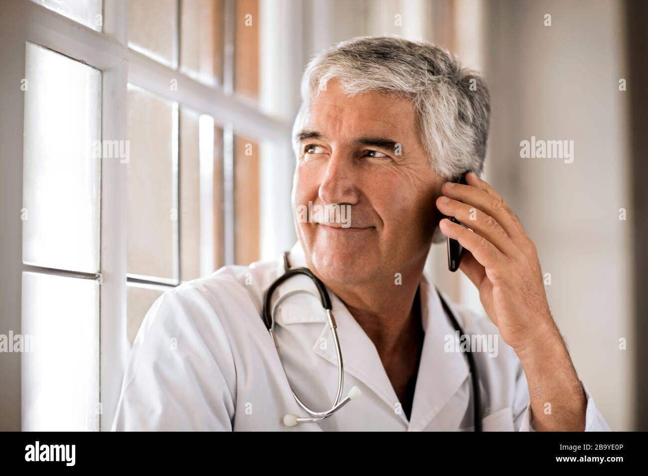 Portrait of male doctor talking on his cell phone. Stock Photo
