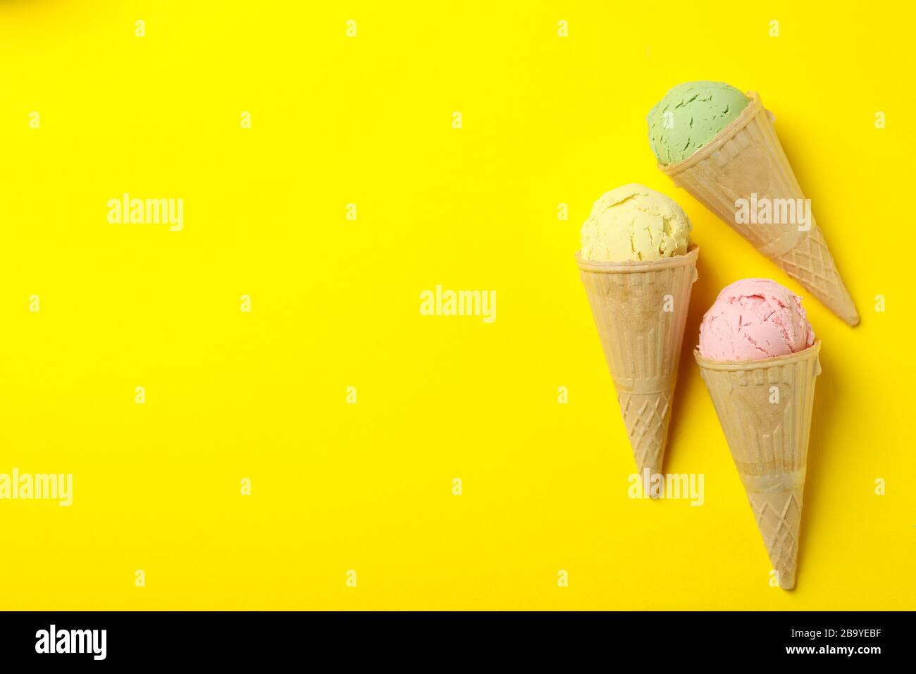 Ice cream in waffle on yellow background, space for text Stock Photo