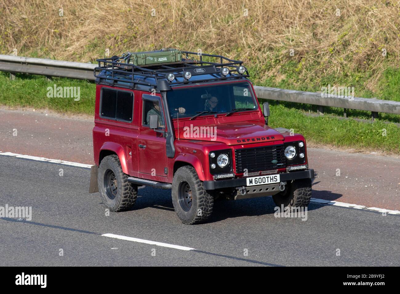 1998 90s red Land Rover 90 Defender County SW TDI; moving vehicles, vehicle driving, roads, motors, motoring  on the M6 motorway highway Stock Photo
