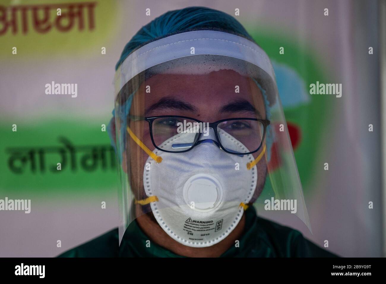 A medical official in a protective gear stands next to a pre-examination tent designated for a rapid health check at  Nepal Medical college hospital during corona virus outbreak threats.Nepal has reported the third corona virus positive case. Stock Photo