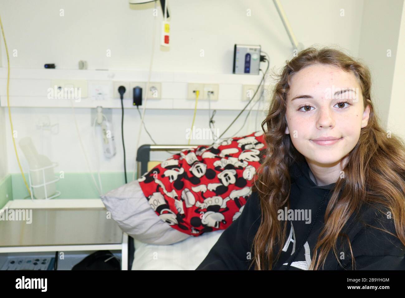 Teenage girl (13) sitting on a hospital bed in Germany Stock Photo Alamy