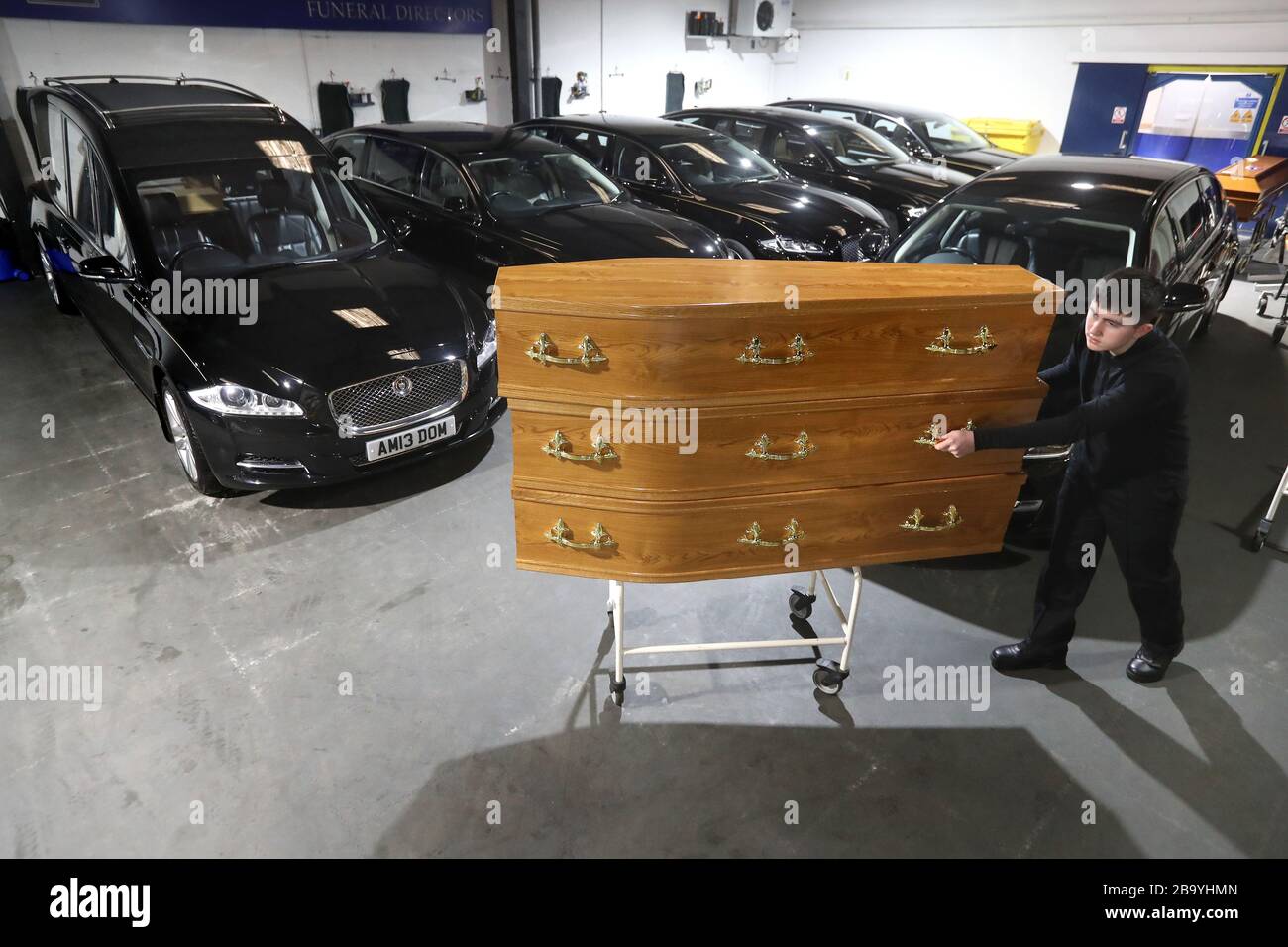 Declan Harley from Anderson Maguire Funeral Directors moves empty coffins at their offices in Glasgow. Funeral directors in Scotland's largest city are facing a backlog and on the verge of running out of mortuary space, the head of one family firm has said. Funerals are unable to take place until deaths have been registered and face-to-face appointments at registry offices are unavailable following coronavirus guidance. Stock Photo