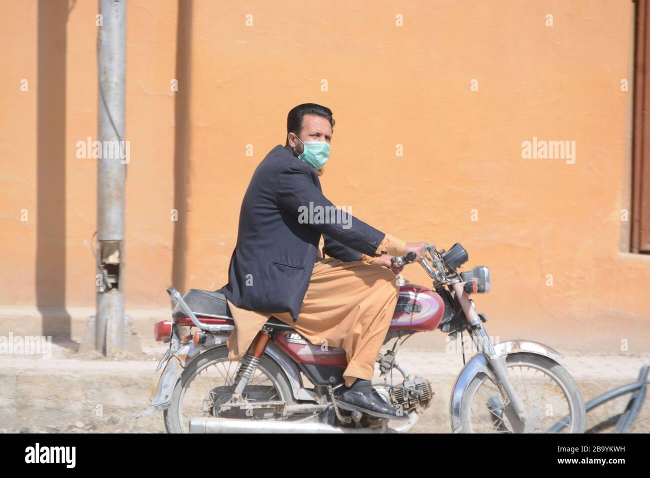 Quetta, Pakistan. 25th Mar, 2020. A man on bike wearing mask during partial lock-down in Balochistan. (Photo by Din Muhammad Watanpaal/ Pacific Press/Sipa USA) Credit: Sipa USA/Alamy Live News Stock Photo