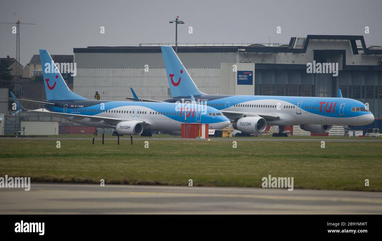 Glasgow, UK. 25th Mar, 2020. Pictured: TUI Airlines stands quiet on the tarmac at Glasgow International Airport. The jets Boeing 737-800MAX Aircraft and Boeing 757-200 Aircraft would normally be ferrying passengers to the Mediterranean and the Canary Islands, however due to the Coronavirus Pandemic all operations have ceased. Credit: Colin Fisher/Alamy Live News Stock Photo