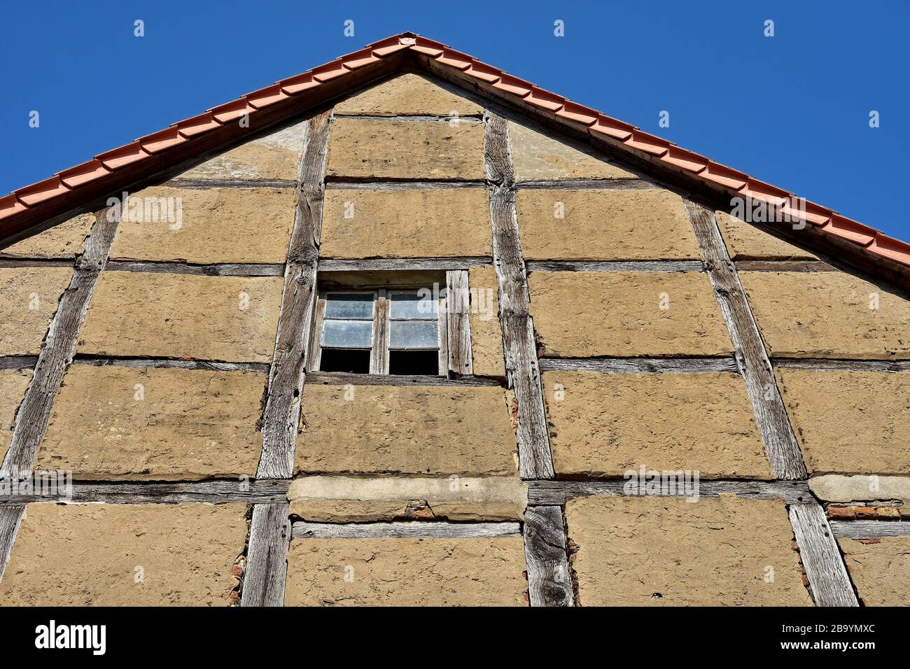 Old half-timbered house facade with exposed wooden beams. The old building is being restored Stock Photo