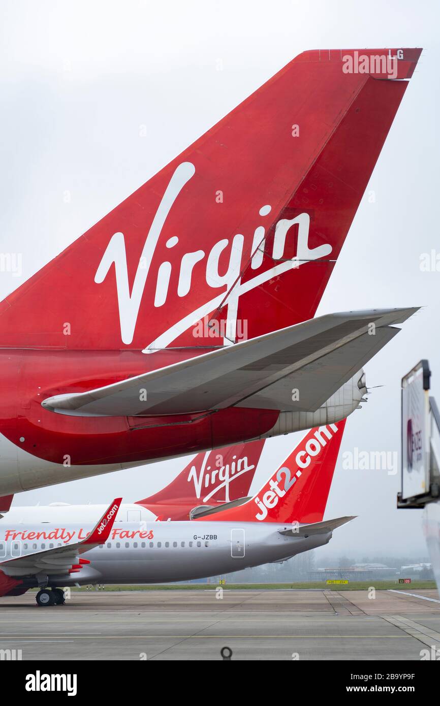 Glasgow, Scotland, UK. 25 March, 2020. Day two of the Government enforced lockdown in the UK. All shops and restaurants and most workplaces remain closed. Cities are very quiet with vast majority of population staying indoors. Pictured; Virgin Atlantic and other passenger aircraft remain grounded and parked at Glasgow Airport. Iain Masterton/Alamy Live News Stock Photo