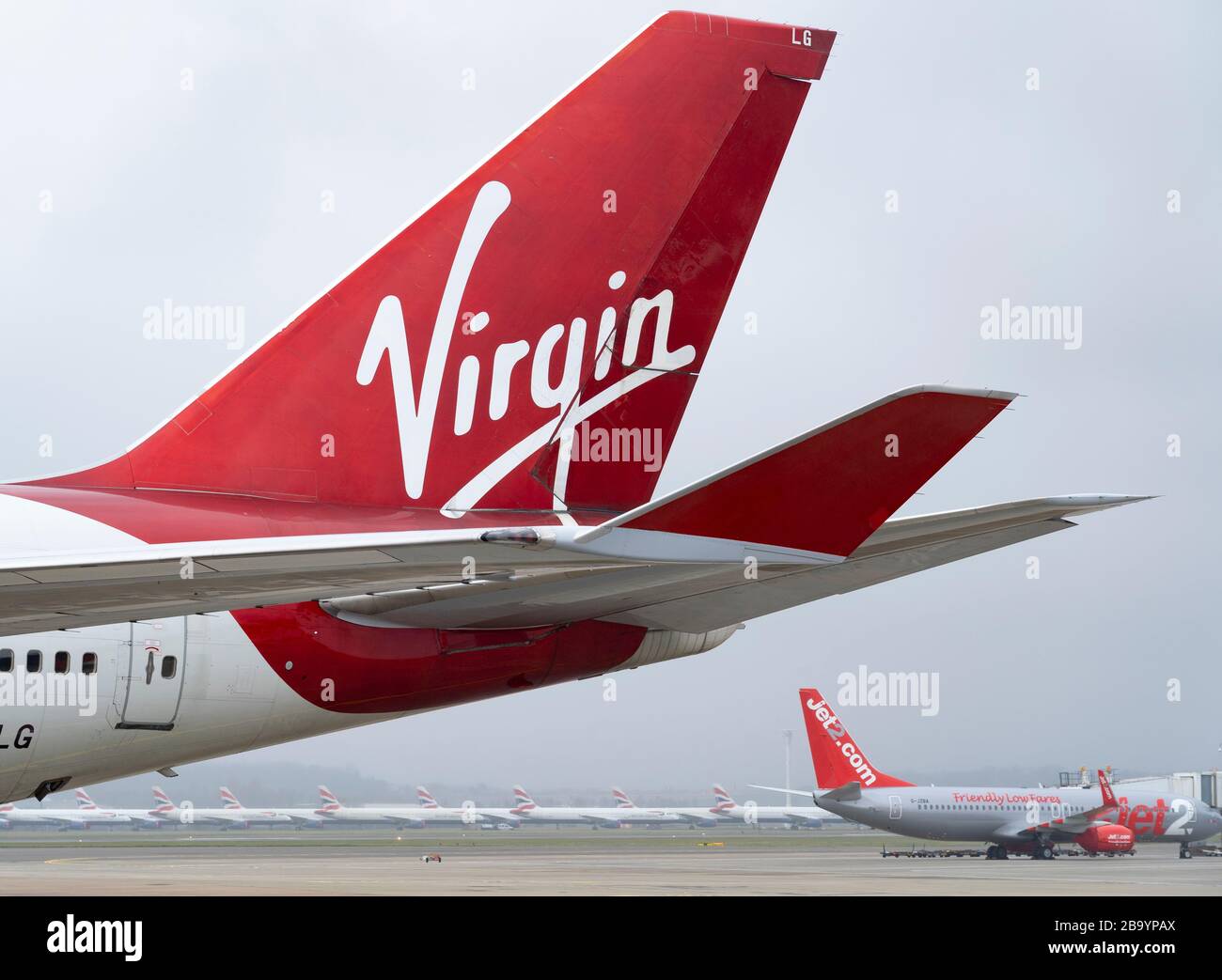 Glasgow, Scotland, UK. 25 March, 2020. Day two of the Government enforced lockdown in the UK. All shops and restaurants and most workplaces remain closed. Cities are very quiet with vast majority of population staying indoors. Pictured; Virgin Atlantic and other passenger aircraft remain grounded and parked at Glasgow Airport. Iain Masterton/Alamy Live News Stock Photo