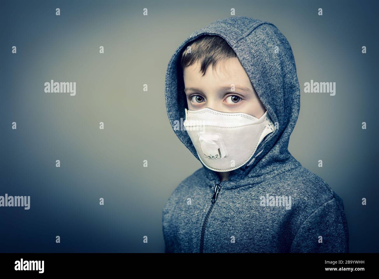 portrait of a 6 year old caucasian boy wearing a protective mask to defend himself from the coronavirus. health prevention and danger concept. Stock Photo