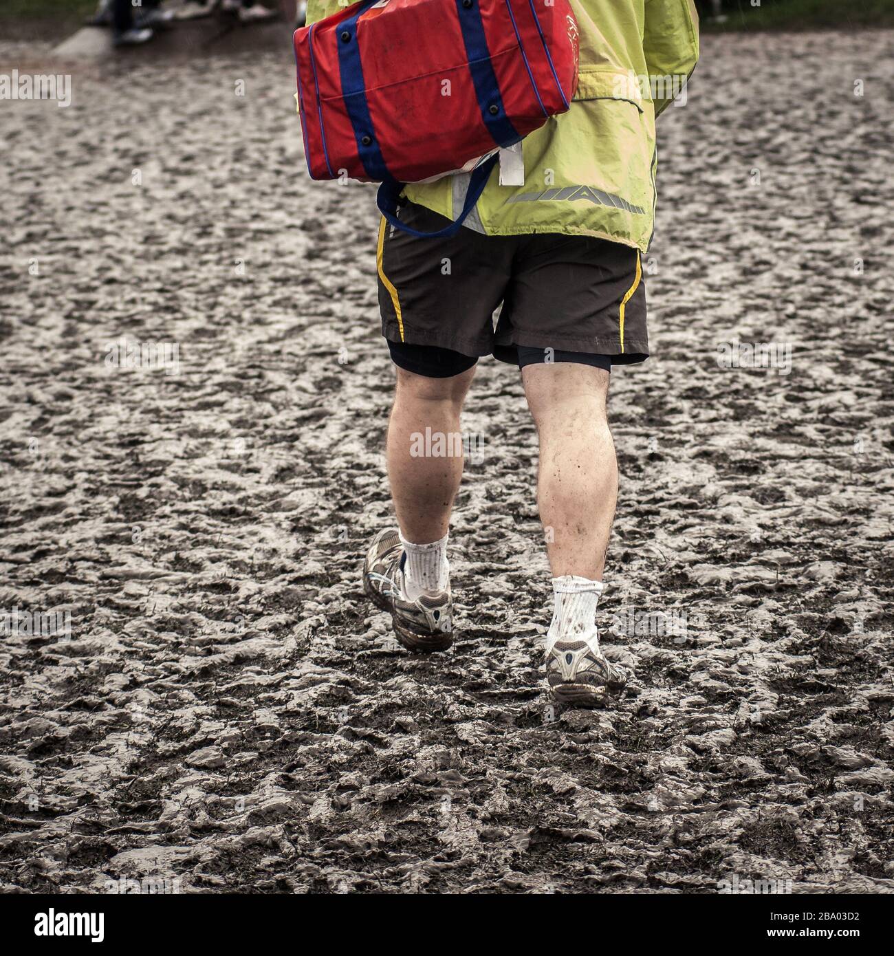 man walking in sportswear in muddy field Stock Photo