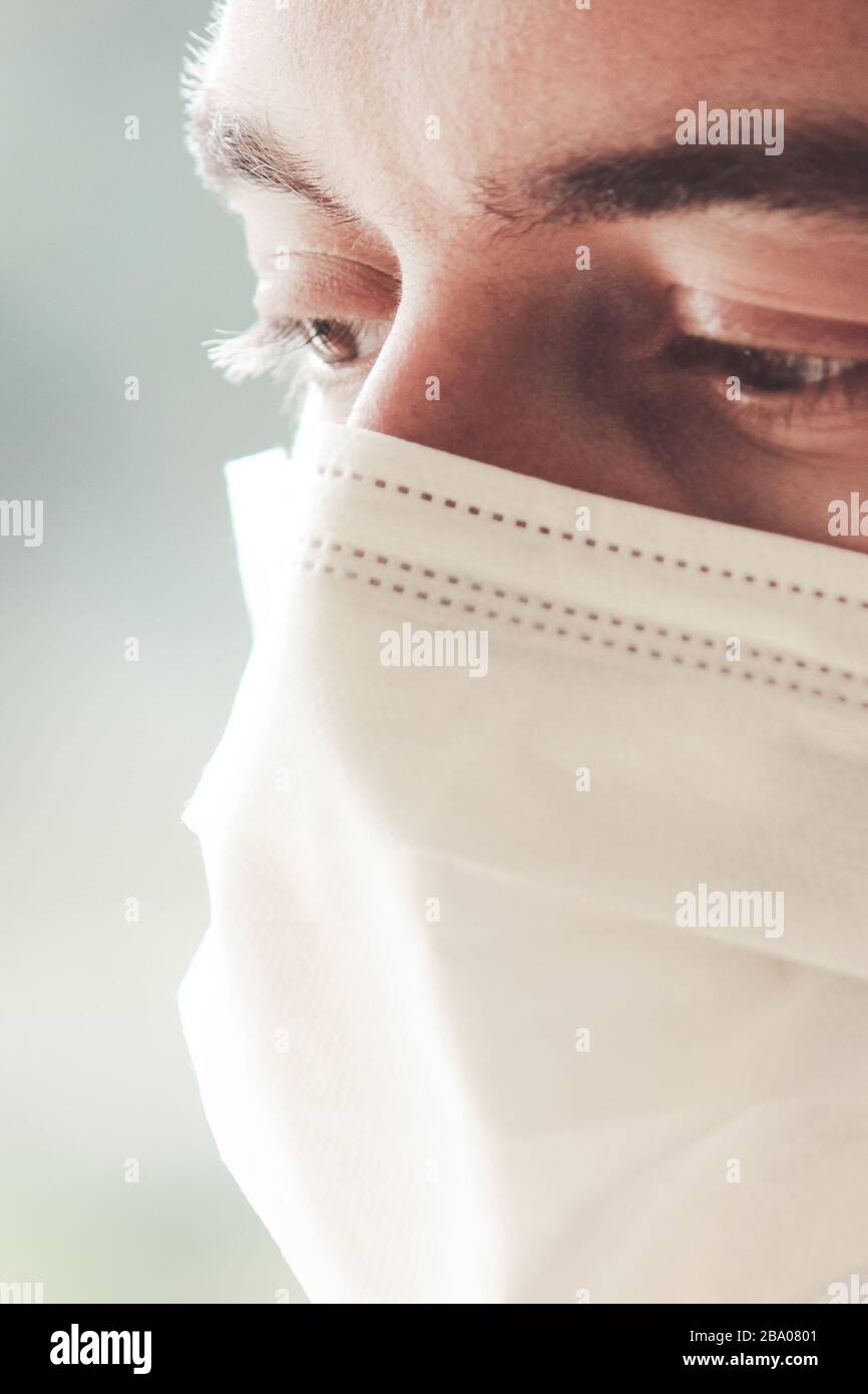 Vertical photo of a young bearded white man with a medical face mask ...