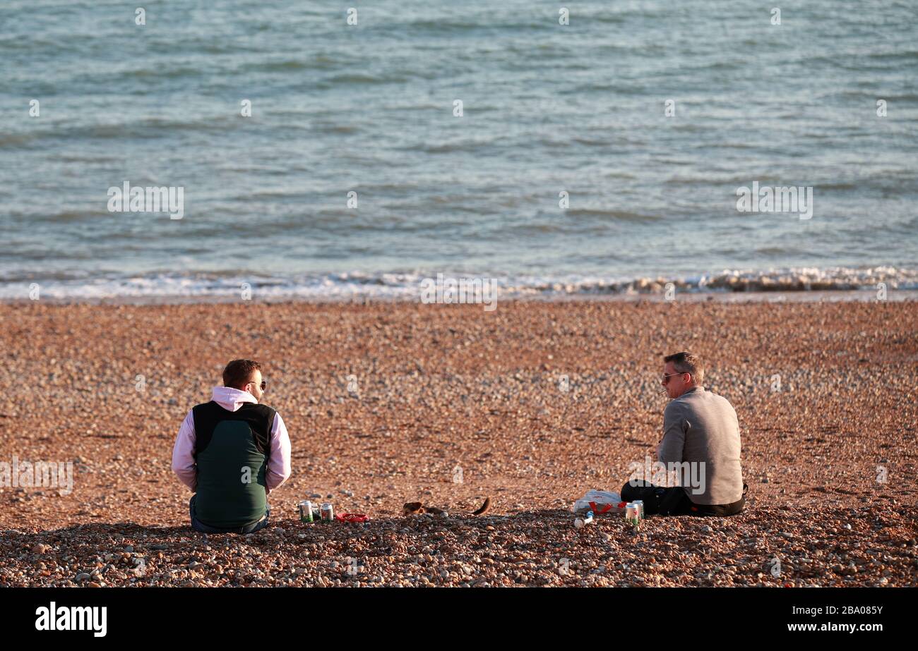 People observing social distancing on Brighton Beach after Prime Minister Boris Johnson made the decision to put the UK in lockdown to help curb the spread of the coronavirus. Stock Photo