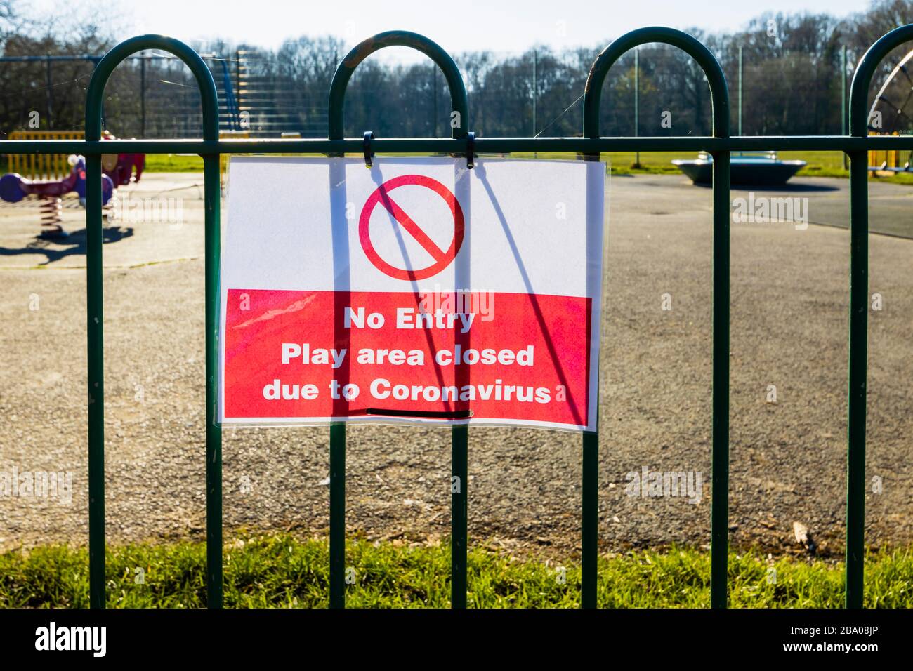 Lockdown: Sign on railings of a playground for children in a park: No Entry; Play area closed due to Coronavirus: St John's Lye, Woking, Surrey Stock Photo