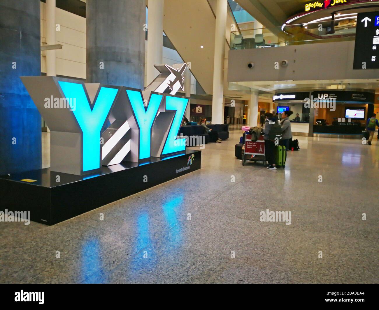Passengers waiting in Toronto Pearson International Airport Terminal One with YYZ sign during Covid-19 Pandemic crisis on March 24, 2020 Stock Photo